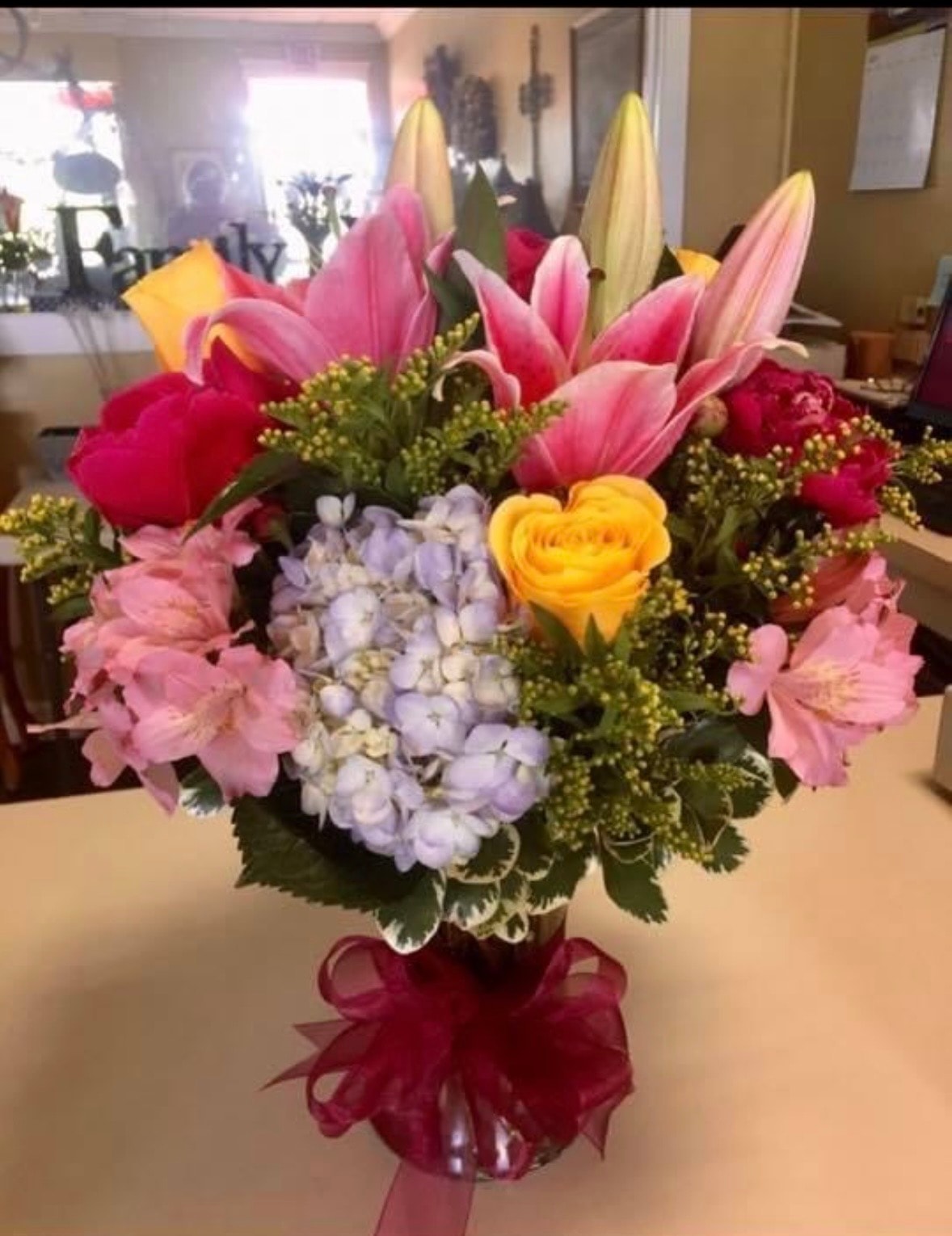 Everyday floral arrangement with pink lilies, yellow roses, lavender hydrangeas and greenery
